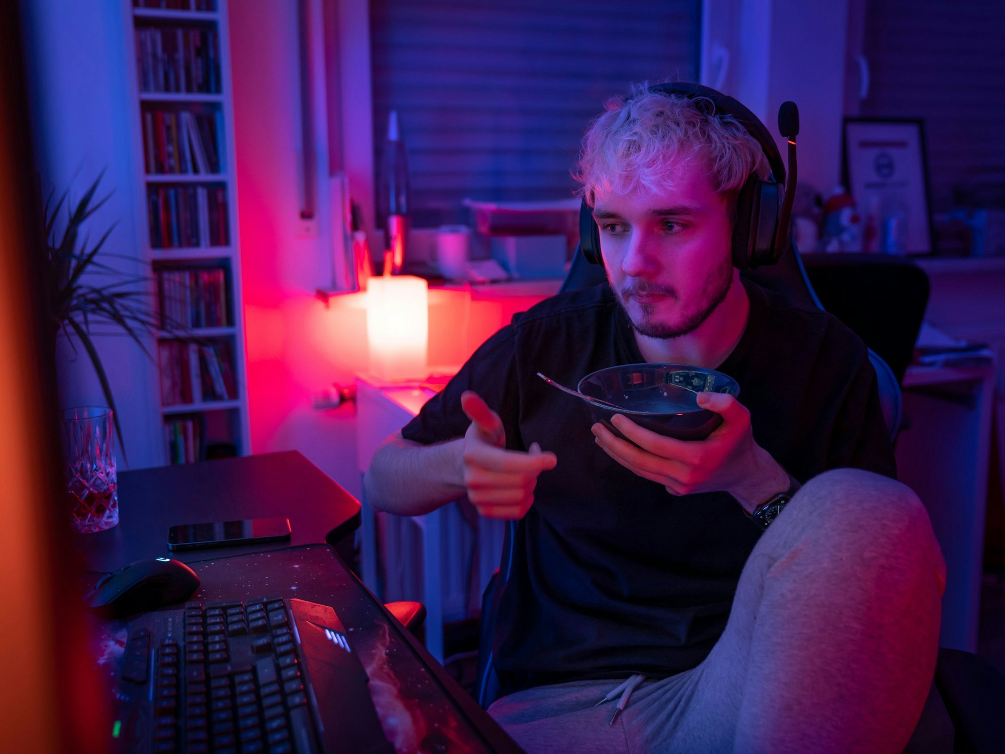 Florian Goerigk sitzt mit einer Schüssel Essen vor seinem Computer.