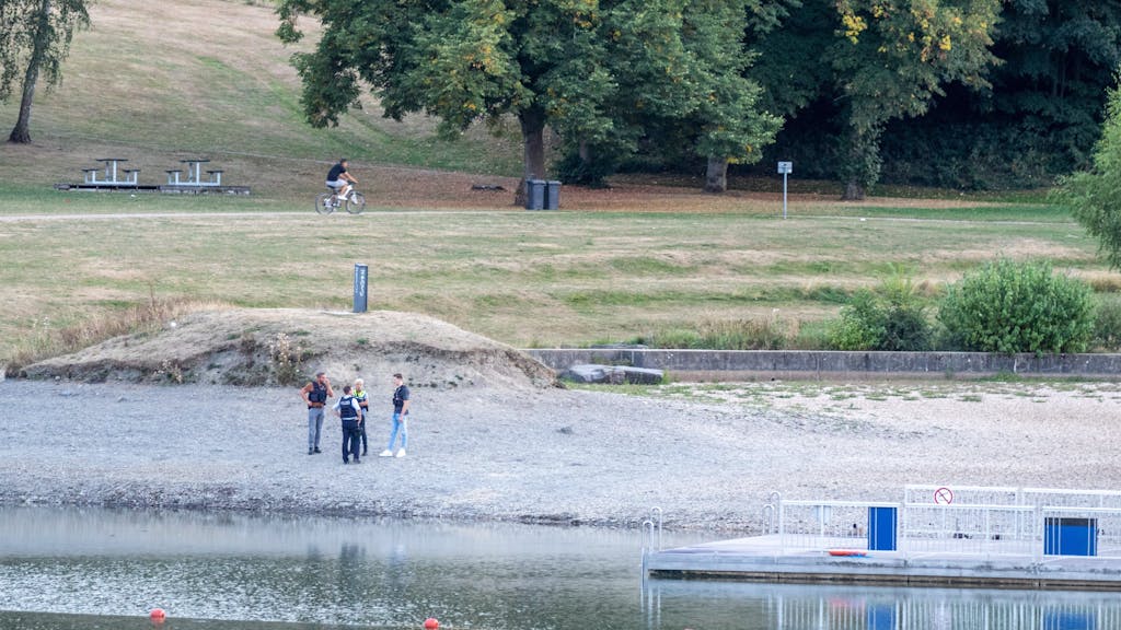 Simmerath: Polizisten stehen am Ufer des Eiserbachsees im Rurseezentrum. Sie wollen den Badeunfall mit zwei toten Jungen aufklären.