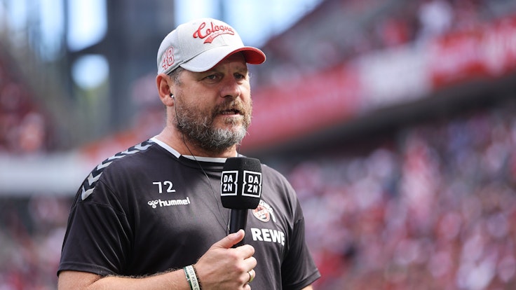 Steffen Baumgart steht am 28. August 2022 mit DAZN-Mikrofon im Stadion.