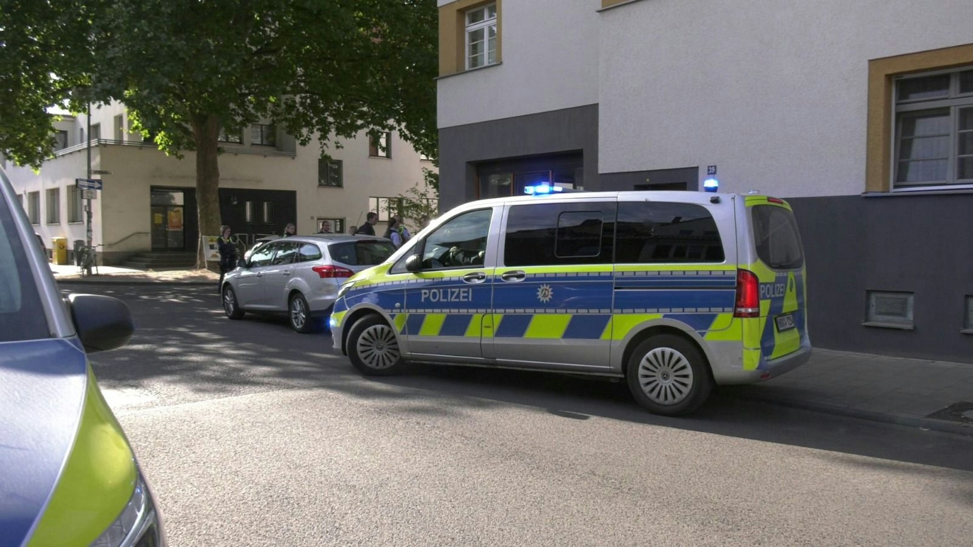 Zwei Polizeifahrzeuge parken in einer Straße.