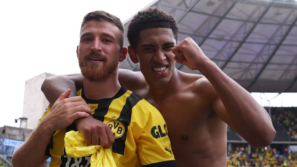 Der oberkörperfreie Jude Bellingham umarmt seinen Dortmund-Kollegen Salih Özcan im Berliner Olympiastadion.