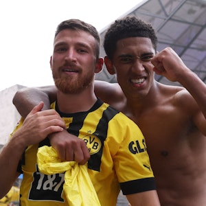 Der oberkörperfreie Jude Bellingham umarmt seinen Dortmund-Kollegen Salih Özcan im Berliner Olympiastadion.