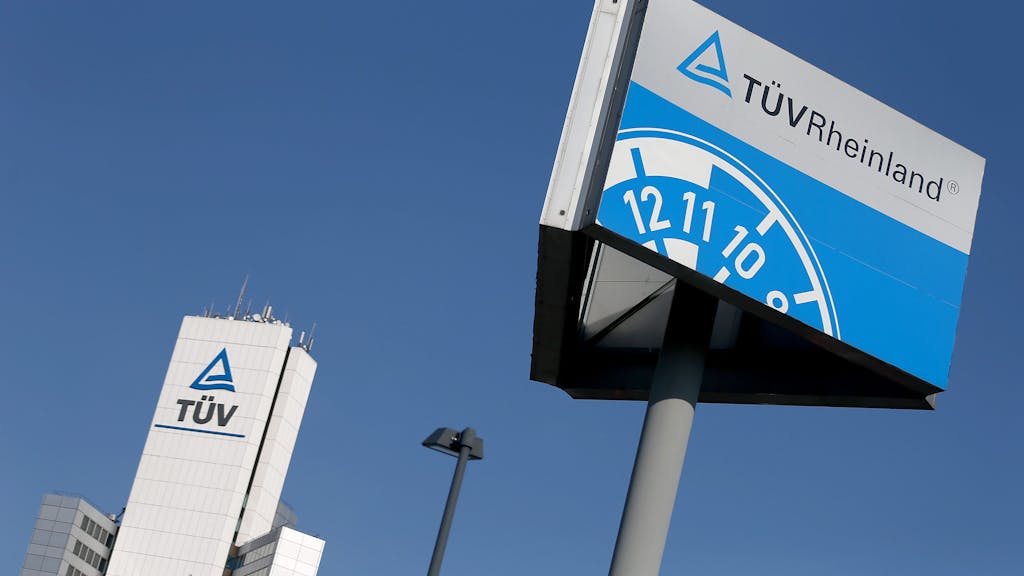 Ein Hinweisschild einer Kfz-Prüfstelle des TÜV Rheinland steht neben der Unternehmenszentrale.&nbsp;