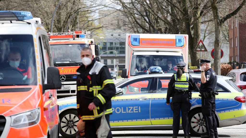Einsatzkräfte von Polizei und Feuerwehr stehen bei einem Einsatz in Hamburg auf einer gesperrten Straße.&nbsp;