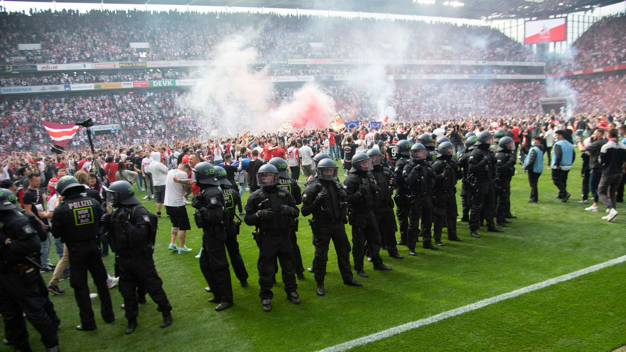 Kölner Fans stürmen nach dem Schlusspfiff den Rasen.