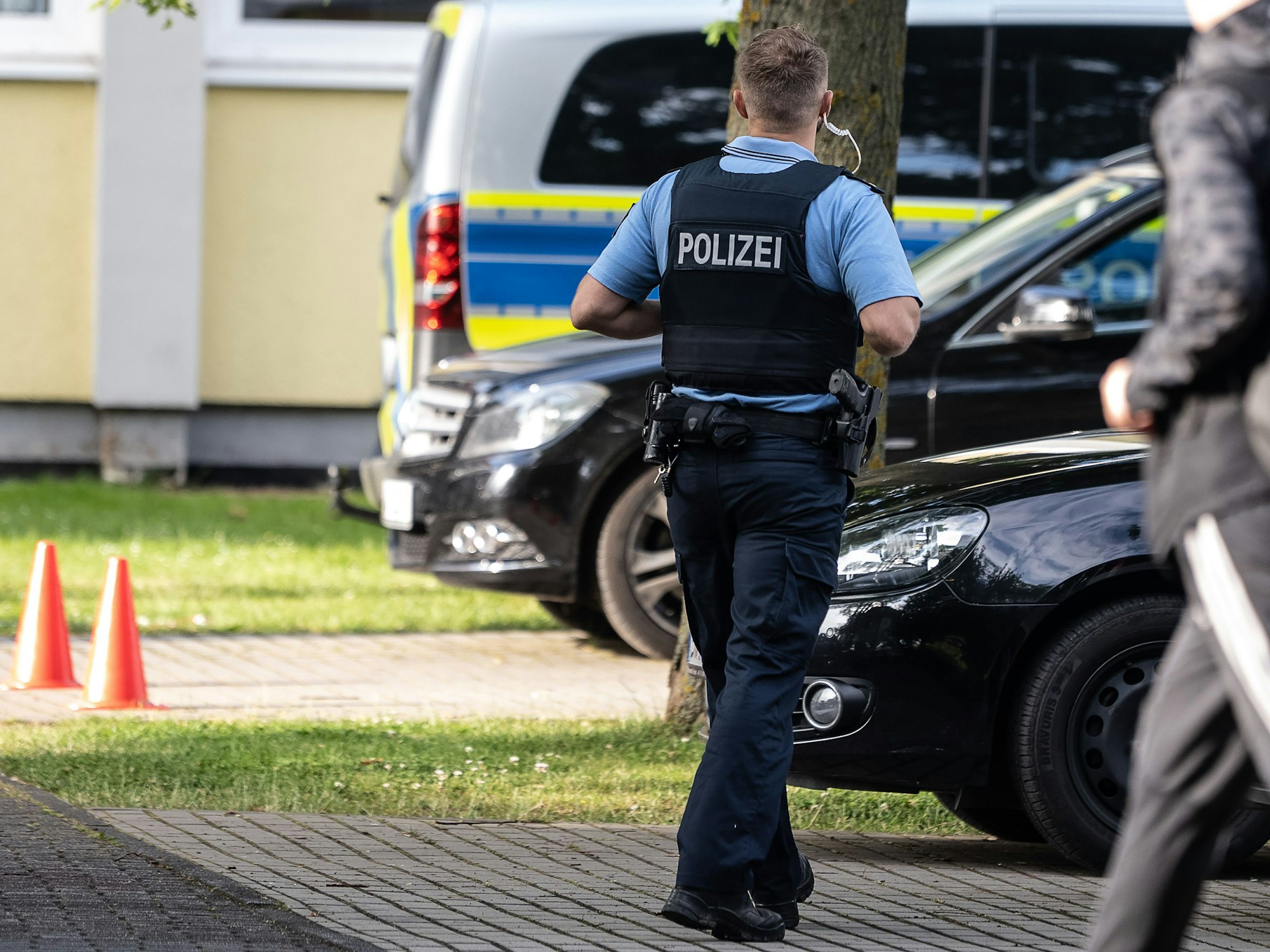 Ein Polizist steht vor Schulbeginn auf einem Parkplatz im nordhessischen Bad Arolsen.