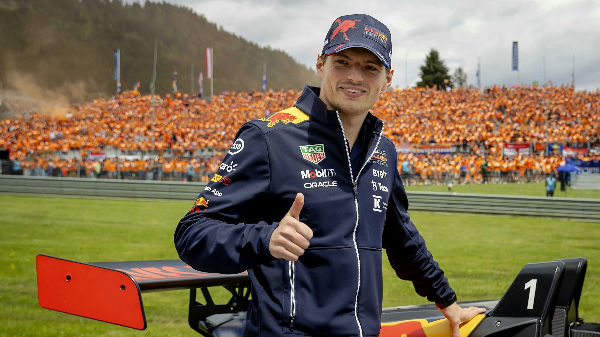 Max Verstappen aus den Niederlanden vom Team Oracle Red Bull zeigt seinen Fans während der Fahrerparade lächelnd einen Daumen nach oben.