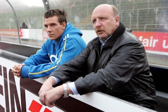 Dieter und Denis Epstein sitzen nebeneinander hinter der Stadion-Bande.