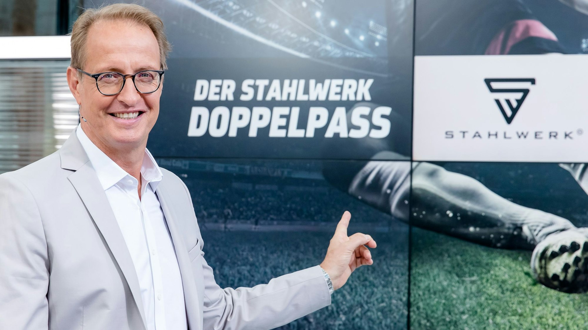 Florian König zeigt auf das Logo vom Sport1-Doppelpass