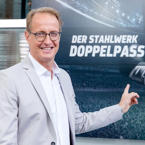 Florian König zeigt auf das Logo vom Sport1-Doppelpass