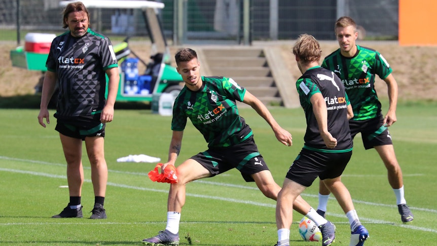 Julian Weigl (M.) im Training von Borussia Mönchengladbach am 2. September 2022 im Zweikampf mit Tony Jantschke. Im Hintergrund schauen Patrick Herrmann und Trainer Daniel Farke zu.