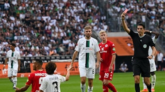 Schiedsrichter Deniz Aytekin (r.) zeigt Gladbach-Verteidiger Ko Itakura (kniend, im weißen Trikot) die Rote Karte nach einer Notbremse im Bundesliga-Duell gegen Mainz 05 (4. September 2022) im Borussia-Park. Aytekin hält die Rote Karte in der Hand.