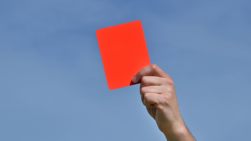 Ein Schiedsrichter zeigt die Rote Karte.