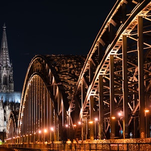 Das Foto zeigt den beleuchteten Dom und die Hohenzollern Brücke.