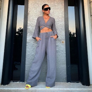 Die Moderatorin Nazan Eckes posiert in einem grauen Zweiteiler und mit großer Sonnenbrille vor einer Hauswand. Das Foto wurde im September 2022 auf Instagram veröffentlicht.