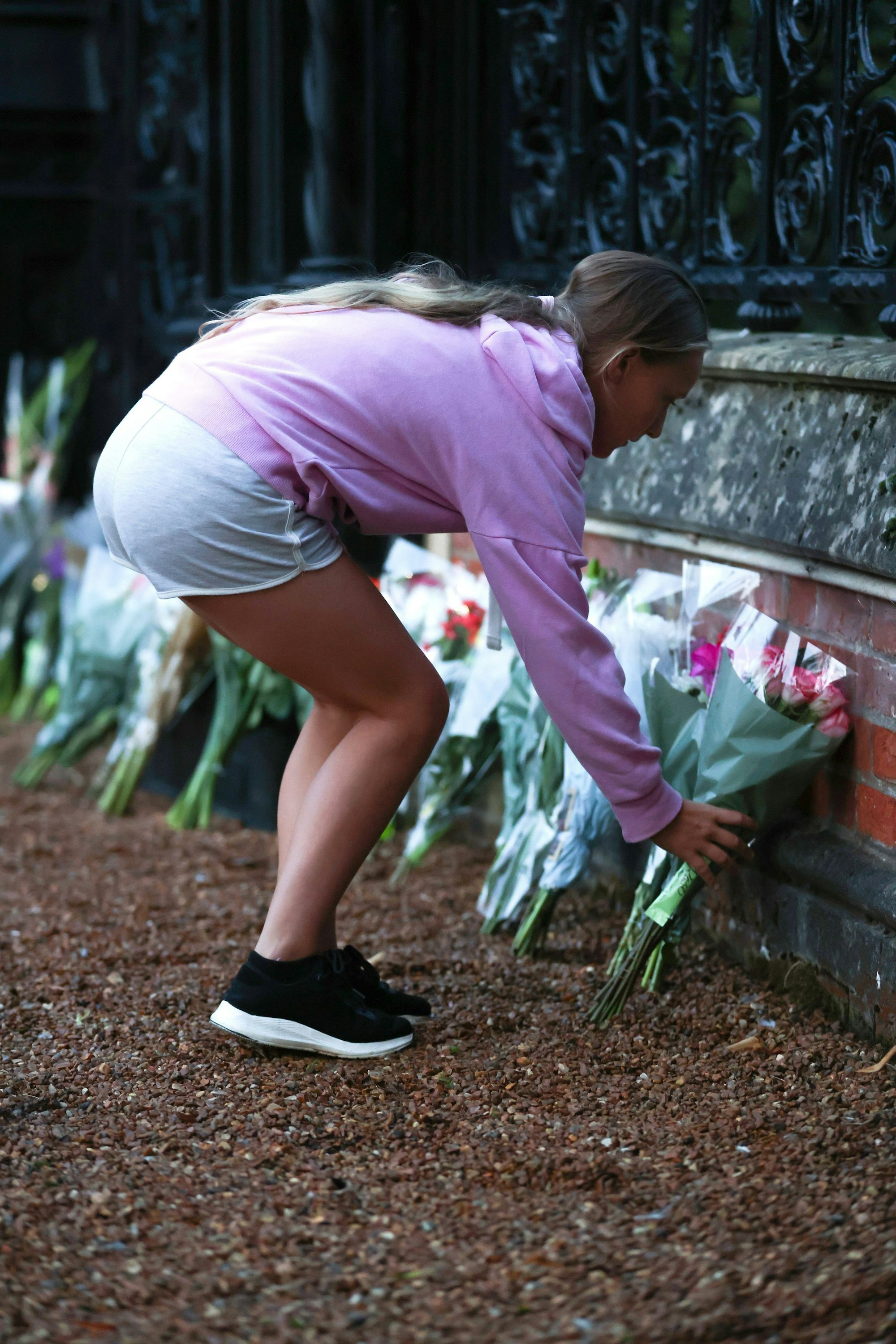 Ein Mädchen bringt Blumen ans Tor von Schloss Sandringham. Auch hier trauern die Menschen um ihre Königin, die am Donnerstag im Alter von 96 Jahren starb.