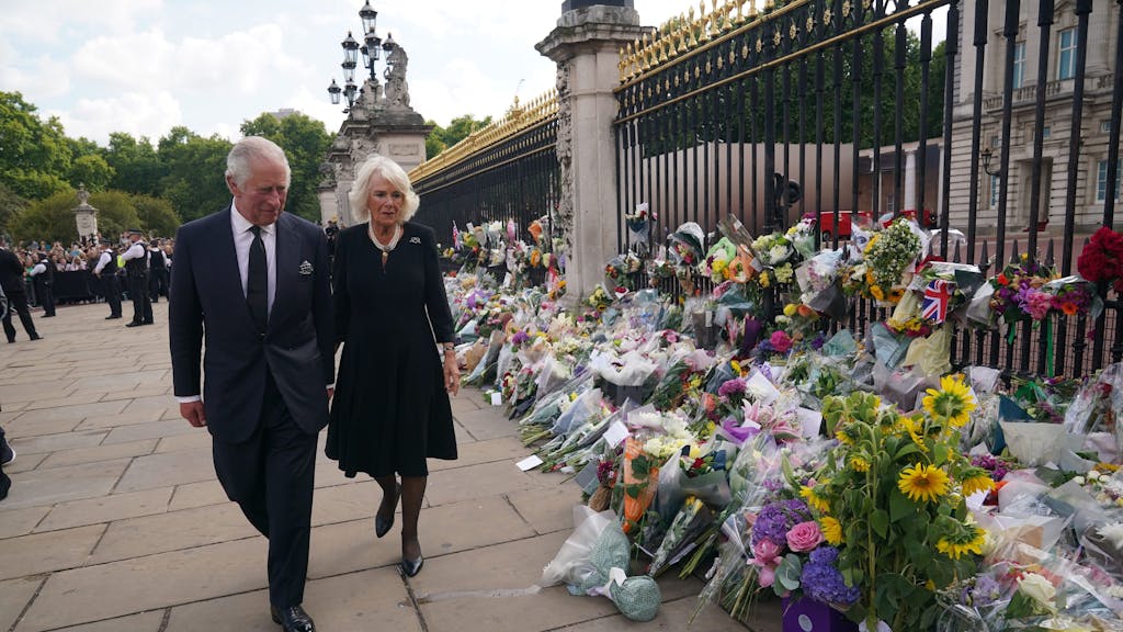 König Charles III. und seine Frau Camilla sehen sich die Blumengestecke und persönlichen Grußworte an, die nach dem Tod von Königin Elizabeth II. vor dem Buckingham-Palast abgelegt wurden.&nbsp;