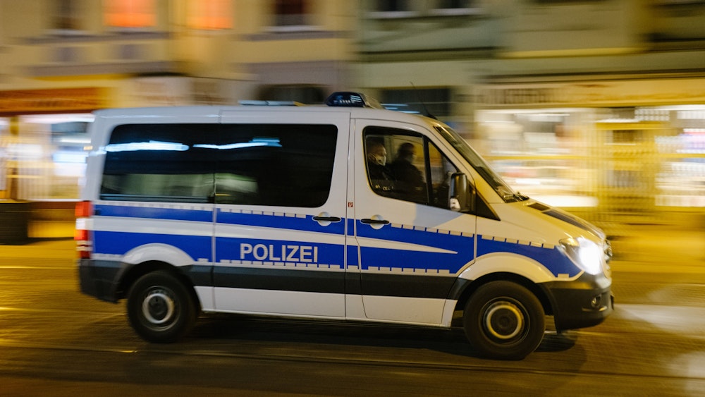 Ein Polizeiwagen fährt über eine Straße.