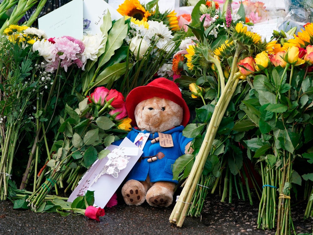 Floral tributes and a Paddington bear teddy are laid at the gates of Balmoral in Scotland, Friday, Sept. 9, 2022, following the death of Queen Elizabeth II on Thursday. (Andrew Milligan/PA via AP)