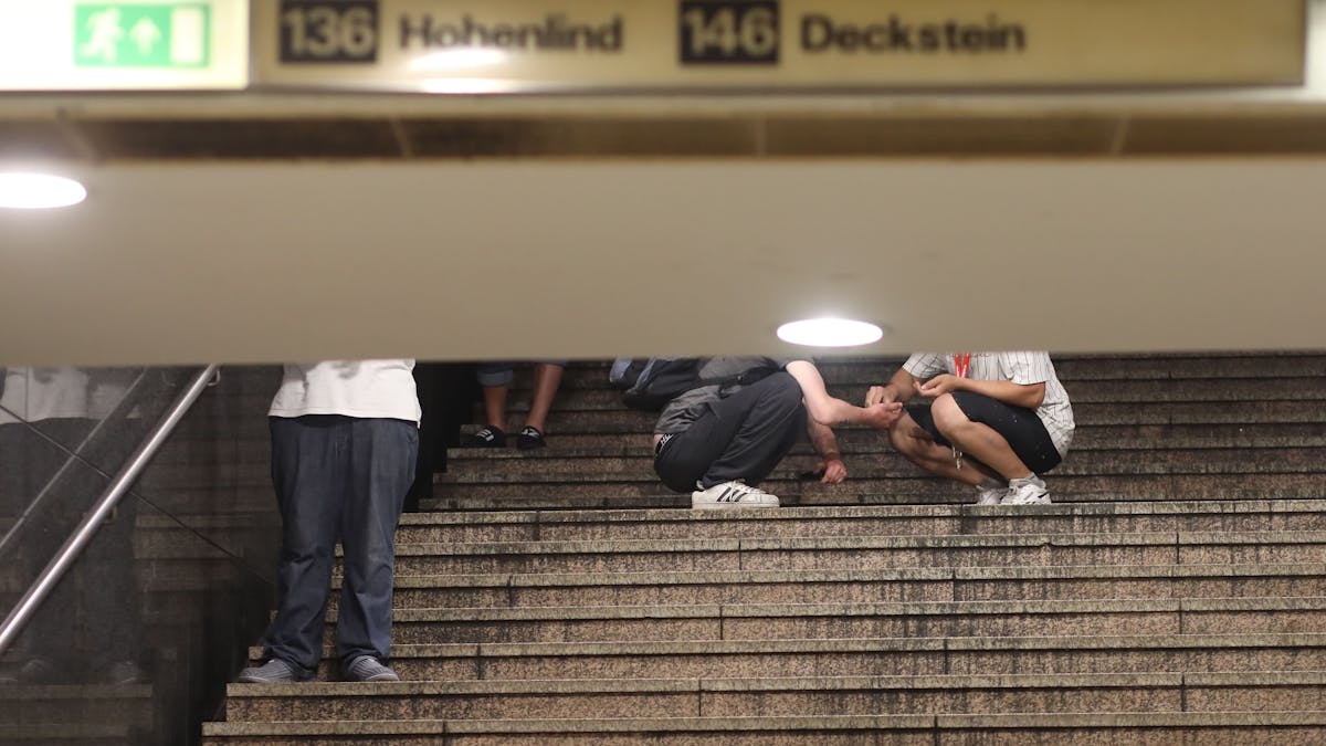 28.06.2022, Köln: An der HUGO Passage am Neumarkt, Dealer und Konsumenten treffen aufeinander. Zwei Passanten auf der Treppe zur U-Bahn hier findet gerade ein Geschäfte statt und wird sich direkt vor Ort ein Schuß gegeben. Foto: Arton Krasniqi