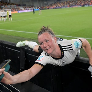 Deutschlands Marina Hegering streckt sich nach dem Spiel nach einem Smartphone.
