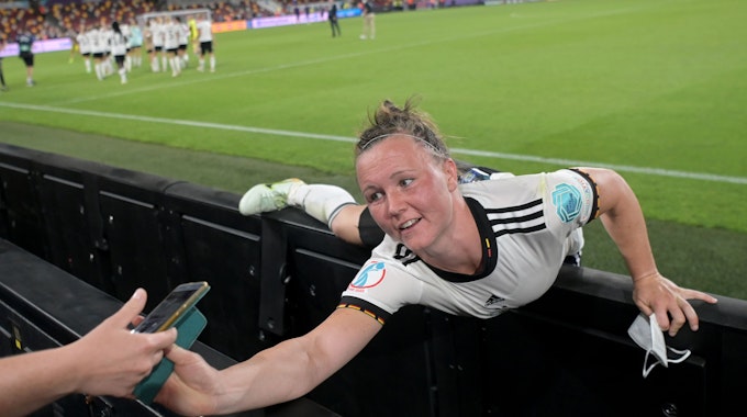 Deutschlands Marina Hegering streckt sich nach dem Spiel nach einem Smartphone.