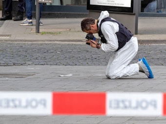 Ein Mitarbeiter der Spurensicherung fotografiert denTatort.
