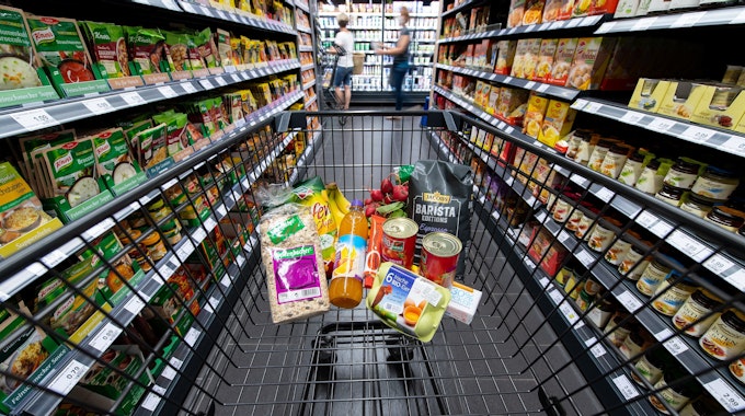 Verschiedene Lebensmittel liegen in unserem Symbolbild in einem Supermarkt in einem Einkaufswagen. Der Zoff zwischen Edeka und einem amerikanischen Mega-Konzern ging jetzt vor Gericht.