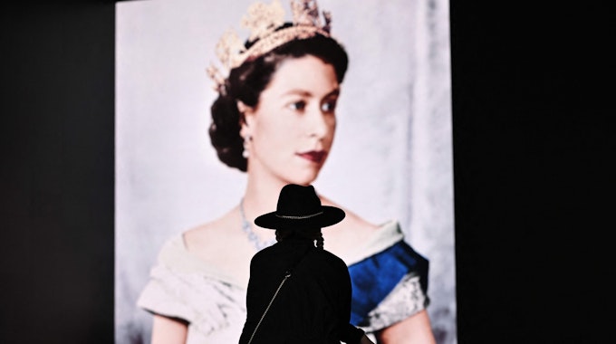 Trauer um die Queen in London: Eine Britin legt am Samstag (10. September) Blumen vor dem Konterfei Elizabeth II. ab.