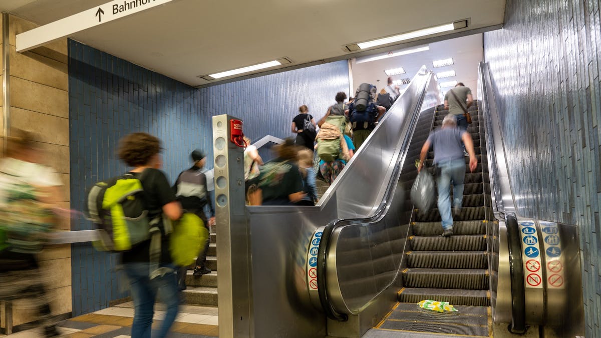 Menschen gehen am Kölner Hauptbahnhof eine Treppe hoch.