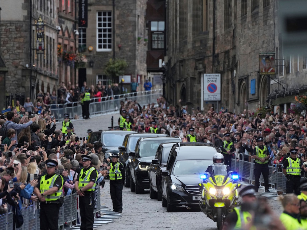 Der Leichenwagen mit dem Sarg von Königin Elizabeth II., der mit der königlichen Standarte von Schottland behängt ist, fährt am 11. September 2022 auf der Royal Mile in Edinburgh.