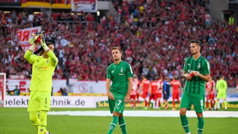 Yann Sommer (l.), Patrick Herrmann (Mitte) und Julian Weigl applaudieren am 11. September 2022 nach dem Match beim SC Freiburg den Fans.