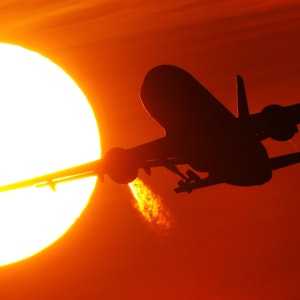 Ein Flugzeug startet am 08. Februar 2011 vom Düsseldorfer Flughafen vor der Kulisse eines spektakulären Sonnenuntergangs.