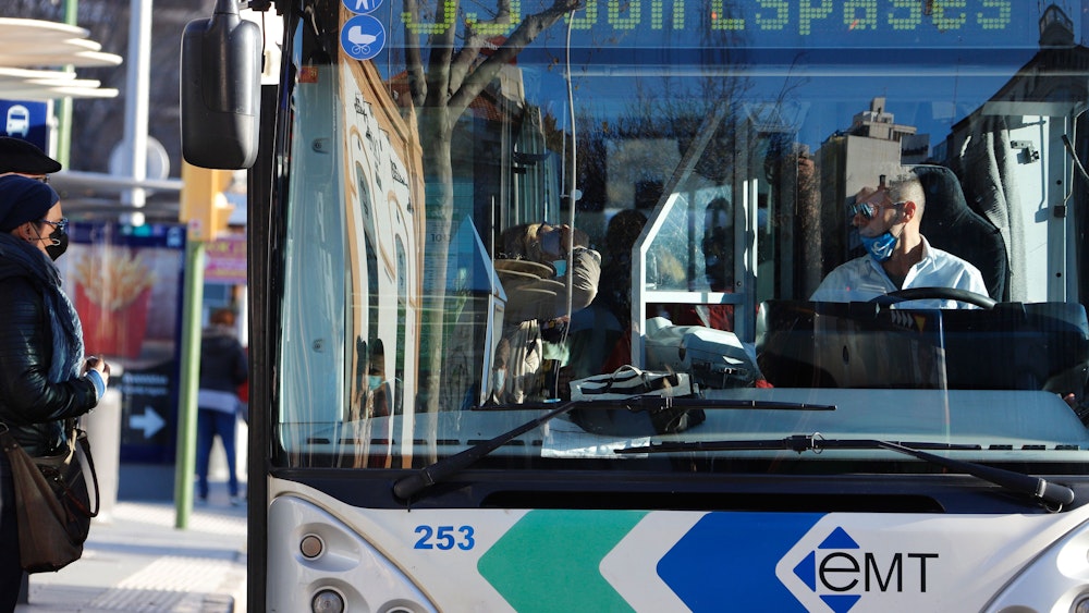 Menschen mit Masken steigen inmitten der Corona-Pandemie in einen Bus ein.