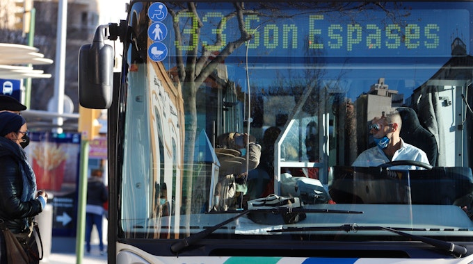 Menschen mit Masken steigen inmitten der Corona-Pandemie in einen Bus ein.