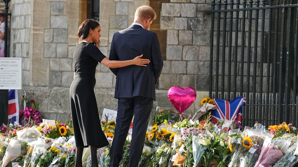 Das Foto vom 10. September 2022 zeigt Meghan Markle und Prinz Harry, wie sie vor unzähligen Blumensträußen anlässlich des Todes von Königin Elisabeth II. stehen.