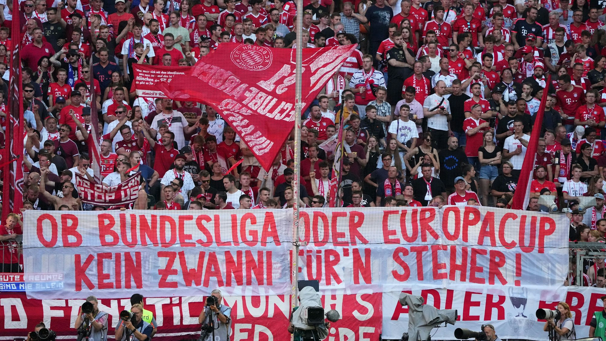 Fans des FC Bayern haben ein Transparent mit der Aufschrift "Ob Bundesliga oder Europacup, kein Zwanni für'n Steher!" am Zaun aufgehängt. 