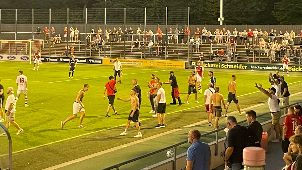 Fans laufen beim Regionalliga-Spiel des 1. FC Köln gegen Rot-Weiß Oberhausen auf das Spielfeld.
