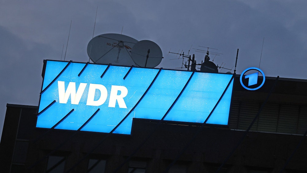 Ein Logo des WDR (Westdeutscher Rundfunk) leuchtet auf dem Dach des Senders.