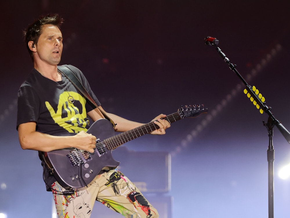 Frontmann Matthew Bellamy von Muse spielt Gitarre auf der Bühne.