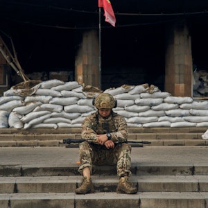 Ein ukrainischer Soldat macht eine Pause auf den Stufen des Rathauses in der Region Charkiw. Aufnahme vom 13. September 2022.