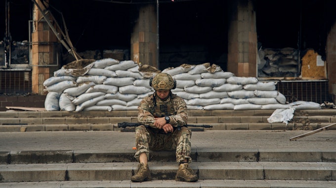 Ein ukrainischer Soldat macht eine Pause auf den Stufen des Rathauses in der Region Charkiw. Aufnahme vom 13. September 2022.