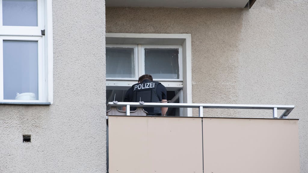 In unserem Symbolbild steht ein Polizist auf einem Balkon eines Berliner Wohnhauses. Der Polizeieinsatz bei einer syrischen Familie in Berlin geriet völlig aus dem Ruder, Videoaufnahmen davon machen in den sozialen Netzwerken die Runde.