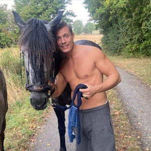 Henrik Stoltenberg posiert gemeinsam mit einem Pferd für ein Foto.