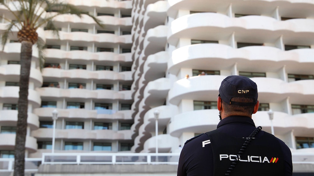 Ein Polizist steht vor einem Hotel auf Mallorca. Die Aufnahme von Juni 2021 dient hier als Symbolfoto.
