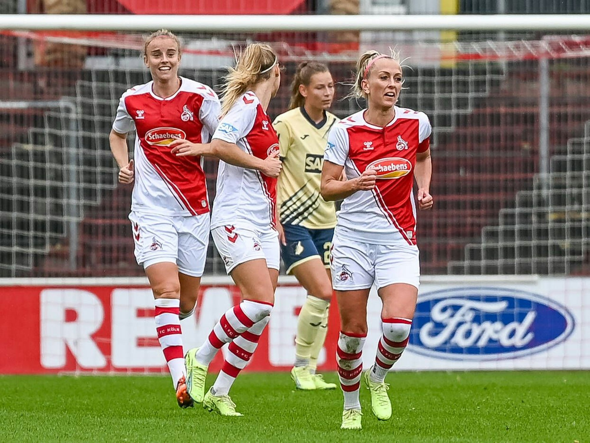 Mandy Islacker jubelt mit zwei Mannschafts-Kolleginnen über ihren Treffer per Elfmeter beimSpiel des 1. FC Köln gegen Hoffenheim am 18. September 2022.
