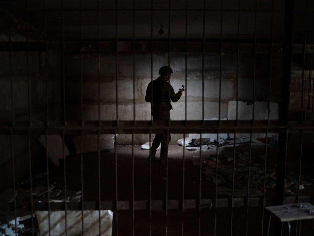 Ein ukrainischer Soldat steht in einem Keller, in dem Menschen während der russischen Besatzung gefoltert worden sein sollen. Räume wie diese sollen als Folterzellen gedient haben.