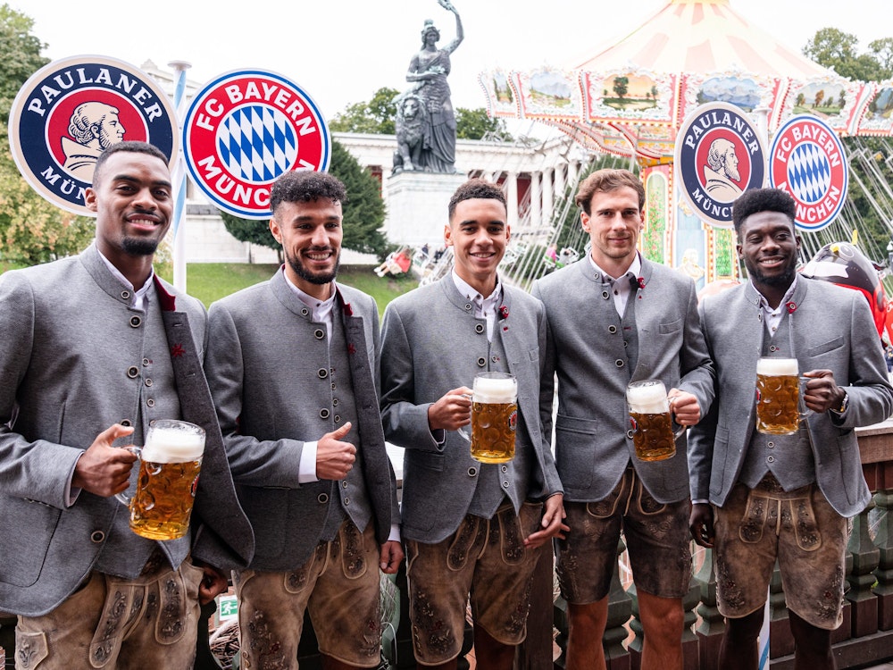 Die FC Bayern München-Spieler Ryan Gravenberch, Noussair Mazraoui, Jamal Musiala, Leon Goretzka und Alphonso Davies posieren auf dem Oktoberfest.