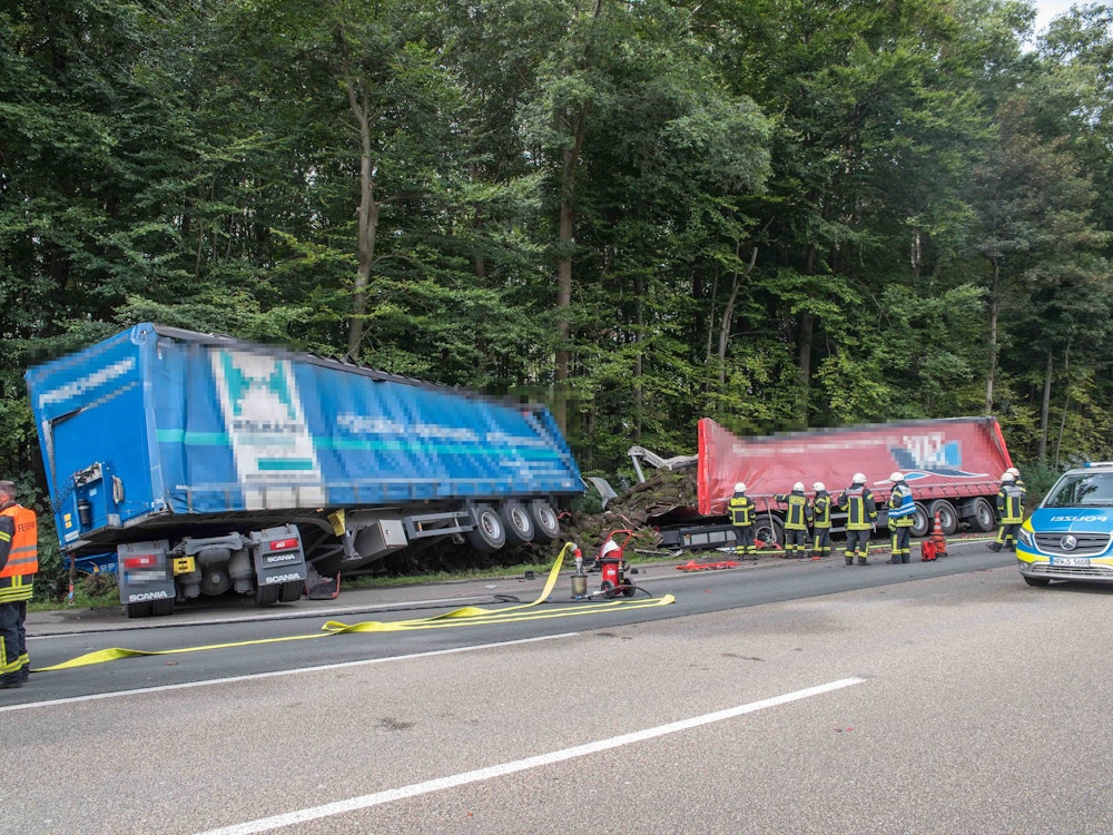 Zwei Lastwagen stehen nach einem Unfall am Fahrbahnrand einer Autobahn.