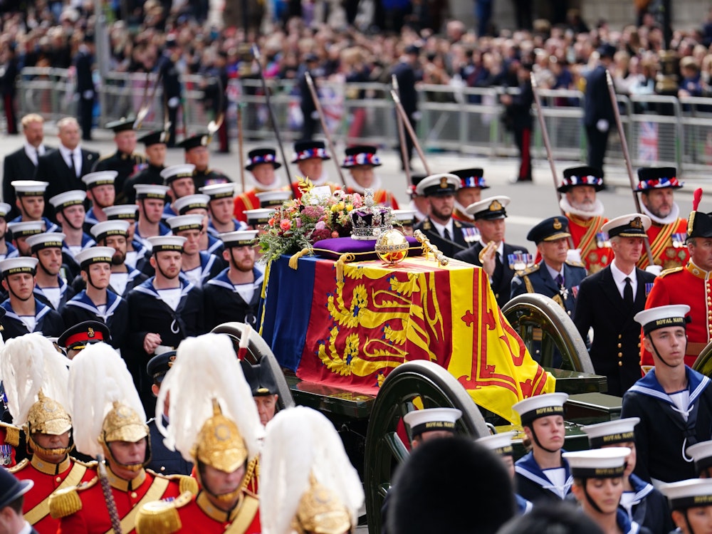 Der Sarg von Königin Elizabeth II. mit der königlichen Standarte, der Imperial State Crown, dem Reichsapfel und Zepter wird in einer feierlichen Prozession nach der Trauerfeier in der Westminster Abbey auf einer Lafette durch die Straßen Londons gezogen.